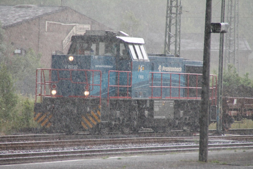 Während eines Starkregens rangiert V150.02 der HGB am alten Bahnbetriebswerk Dillenburg vorbei.