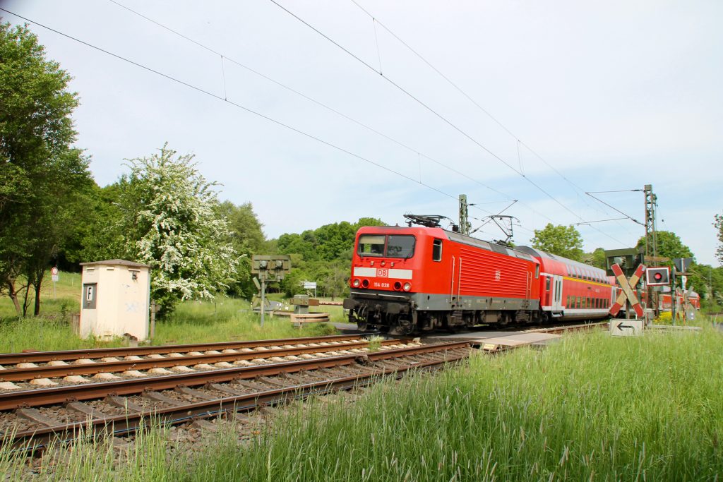 114 038 überquert mit ihrem Zug den Bahnübergang bei Dillheim auf der Dillstrecke, aufgenommen am 22.05.2016.