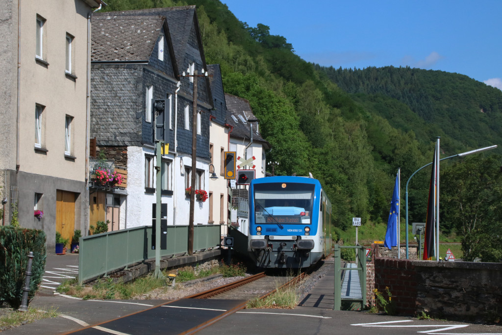 650 131 überquert den ersten der beiden Bahnübergänge in der Moselstraße in Kövenig auf der Moselweinbahn, aufgenommen am 04.07.2017.