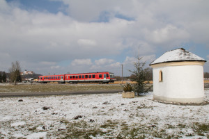 628 584 an einer Kapelle bei Altenmark auf der Traun-Alz-Bahn, im Hintergrund ist das Kloster Baumburg, aufgenommen am 20.03.2018.