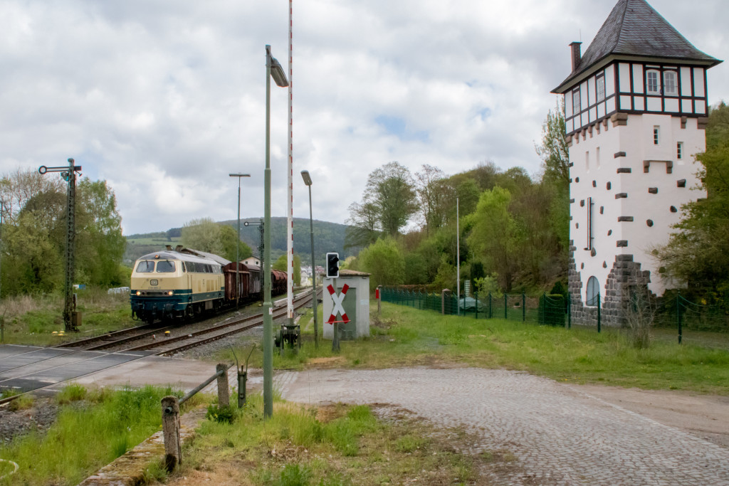 218 003 am Wasserturm von Bad Salzschlirf auf der Vogelsbergbahn, aufgenommen am 28.04.2019.