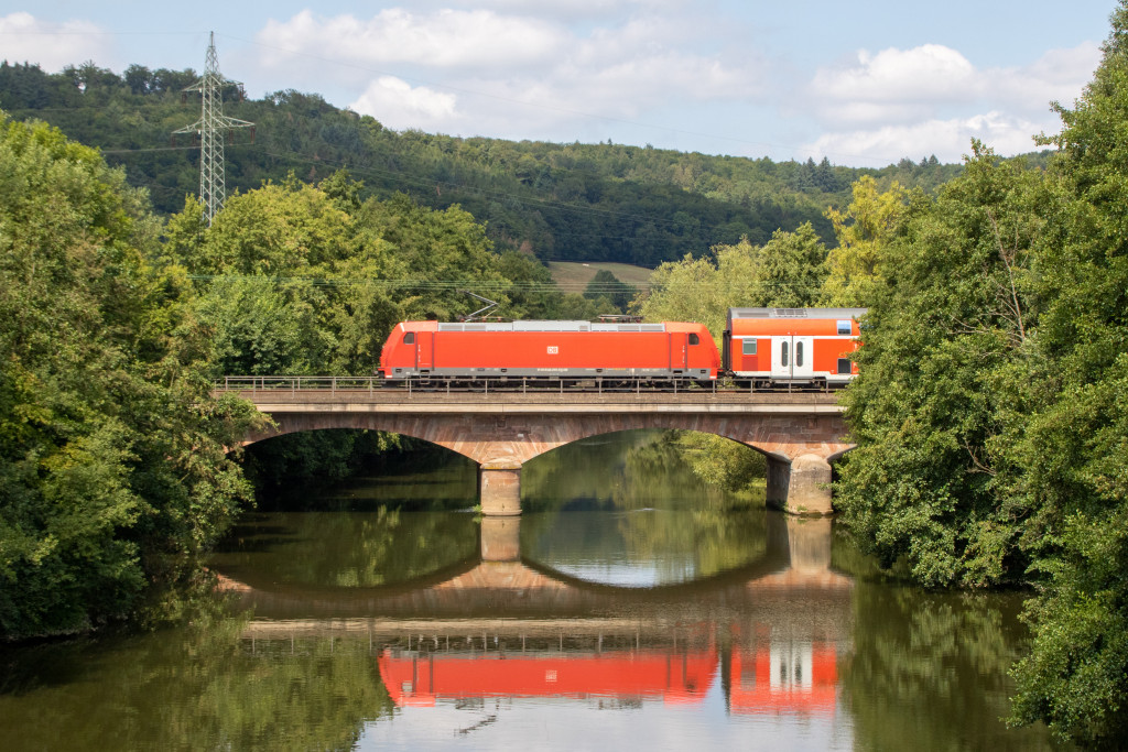 146 255 schiebt ihren Zug aus Doppelstockwagen über die Lahnbrücke bei Marburg-Gisselberg, aufgenommen am 04.08.2019.