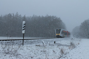Im Schneetreiben am 24.01.2015 passiert ein GTW 2/6 der HLB den ehemaligen Bahnübergang zwischen Lich und Langsdorf auf der Lahn-Kinzig-Bahn.