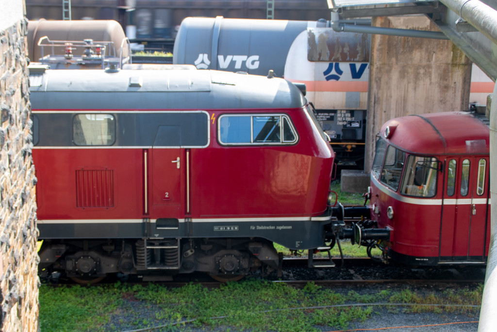 Im Bahnbetriebswerk Linz (Rhein) verstecken sich eine 215 und ein Schienenbus, aufgenommen am 11.08.2021.