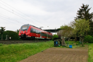 442 280 verschwindet in einer funktionslosen Brücke bei Okarben auf der Main-Weser-Bahn, aufgenommen am 24.04.2022.