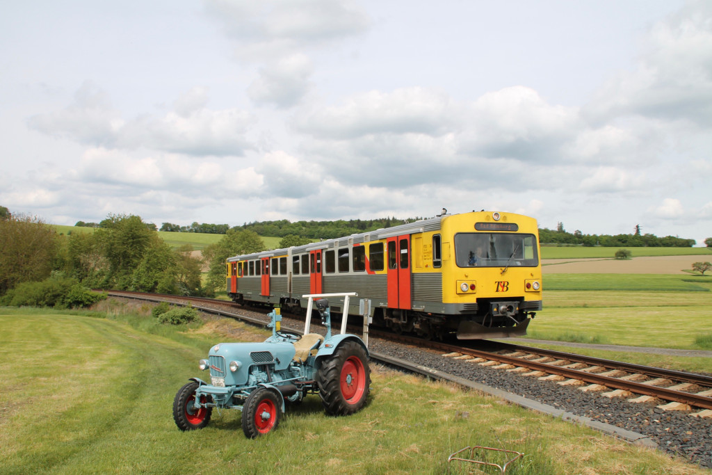 Ein VT2E der HLB begegnet einem Eicher Traktor in Hundstadt auf der Taunusbahn, aufgenommen am 21.05.2016.